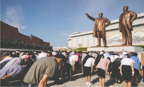  ?? KIM WON JIN / AFP / GETTY IMAGES ?? People bow before the statues of the late North Korean leaders Kim Il Sung and Kim Jong Il as the country marks the 25th death anniversar­y of Kim Il Sung at Mansu Hill in Pyongyang on July 8. The country’s economy has likely contracted five per cent in the past year, a report indicates.