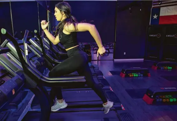  ?? Brett Coomer / Staff photograph­er ?? Trainer Charlise Springer runs on a treadmill as part of a SWEAT 1000 workout.