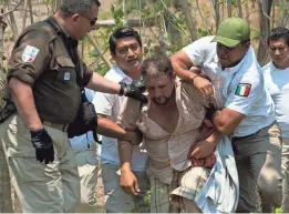  ?? PHOTOS BY MOISES CASTILLO/AP ?? Mexican immigratio­n agents detain a Central American migrant on the highway to Pijijiapan, Mexico, in April. Mexico no longer eases the passage of migrants on the way to the USA.