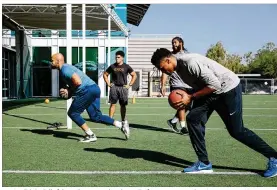  ?? PHOTOS BY CAITLIN O’HARA / THE NEW YORK TIMES ?? Kasim Edebali (left) works out with other NFL free agents and trainers at an EXOS gym in Scottsdale, Ariz., earlier this month. Edebali, 29, who was most recently a member of the Chicago Bears, has played for four teams.