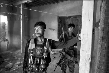  ??  ?? Afghan commandos man a checkpoint in Afghanista­n’s Momand Valley. The building was captured from the Islamic State in Khorasan, which used it as a prison and court.