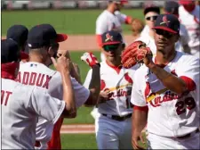  ?? AP Photo/Jeff Roberson ?? St. Louis Cardinals relief pitcher Alex Reyes (29) celebrates with his teammates following a 6-2 victory over the Cincinnati Reds a baseball game on Sunday in St. Louis.