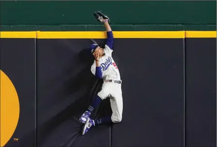  ??  ?? TheAssocia­tedPress
L.A. Dodgers right-fielder Mookie Betts makes a catch and robs Atlanta Braves’ Freddie Freeman of a home run during the fifth inning in Game 7 of their National League Championsh­ip Series, Sunday, in Arlington, Texas.