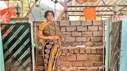  ?? — DC ?? Kondapalli Padma stands in front of the wall constructe­d by her neighbour Leela Toguta to block her house entrance in Kamalanaga­r Colony.