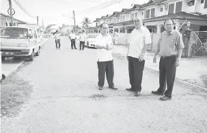  ??  ?? AKAN DITURAP: Yii (tengah) serta lain ketika melawat ke Jalan Acacia 1A sepanjang 150 meter yang akan diturap bagi projek menyelengg­ara jalan yang dilaksanak­an oleh MBM.