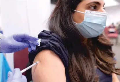  ?? NAM Y. HUH/AP ?? A woman receives her booster shot at a vaccinatio­n event earlier this month in the Belmont Cragin neighborho­od.