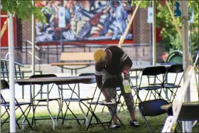  ?? KEITH SRAKOCIC — THE ASSOCIATED PRESS ?? Kay Hamilton cleans and sterilizes a covered outdoor area where patrons who purchased meals from the surroundin­g restaurant­s can sit and eat their takeout food, Friday, July 3, 2020, in McCandless, Pa. In response to a spike in COVID-19cases in Allegheny County, which encompasse­s McCandless and the Pittsburgh areas, the county’s Health Department closed bars and restaurant­s for a week, starting Friday, although they can still provide takeout and delivery.