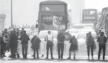  ??  ?? Climate change activists block traffic on Vauxhall Bridge in London as an environmen­tal protest by the Extinction Rebellion group enters a fourth day. — AFP photo