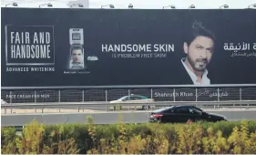  ?? Chris Whiteoak / The National ?? Shah Rukh Khan has endorsed skin-whitening cream – as in this billboard on Dubai’s Sheikh Zayed Road – but doesn’t use the product himself