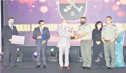 ?? ?? ANUGERAH: Hajiji menyampaik­an Anugerah Khas Ketua Menteri kepada wakil Markas Divisyen Kelima Infantri Malaysia sempena Majlis Anugerah Inovasi Sektor Awam Sabah (iSAS) 2021.