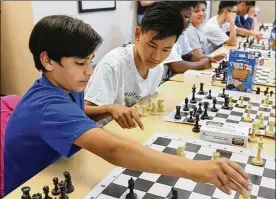  ?? PHIL MASTURZO/ AKRON BEACON JOURNAL ?? Habibullah­Momand (left) gets a little help fromAlaa Alhamad with a chessmove at the NorthHill Library on Thursday in Akron.