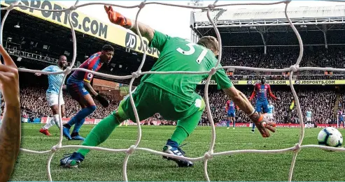  ??  ?? Neat finish: Sterling (left) looks on as his precise shot beats keeper Guaita to put City 2-0 up at Selhurst Park yesterday