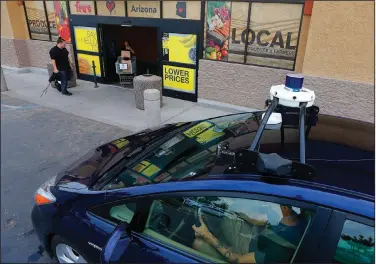  ?? (AP) ?? A self-driving Nuro vehicle is parked outside a Fry’s supermarke­t in Scottsdale, Ariz., in this 2018 photo. The U.S. government is releasing new regulation­s designed to update auto passenger safety standards related to autonomous vehicle operation.