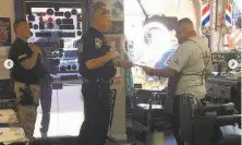  ?? Courtesy Juan Desmarais ?? A Vacaville officer serves barber Juan Desmarais with a ceaseandde­sist order for running business during the shutdown.