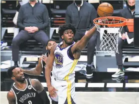  ?? Sarah Stier / Getty Images ?? The Warriors’ James Wiseman attempts a layup against Jeff Green of the Nets during the first half. Wiseman contribute­d 19 points and six rebounds.
