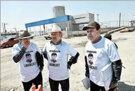  ?? YURI CORTEZ/GETTY-AFP ?? Three supporters of imprisoned Mexican drug lord Joaquin “El Chapo” Guzman wear T-shirts against his extraditio­n this week in front of the Altiplano prison.