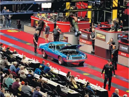  ?? PATRICK CONNOLLY/ORLANDO SENTINEL ?? A 1974 Chevrolet Camaro rolls across the auction block Jan. 6 at Mecum Kissimmee at Osceola Heritage Park. The 11-day event made $217 million in sales, the highest total achieved by a single collector car auction.