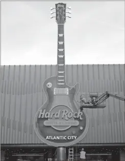  ?? / AP-Wayne Parry ?? Workers put the finishing touches on a large electric guitar replica on the front of the Atlantic City, N.J., Hard Rock casino — the former Trump Taj Mahal.