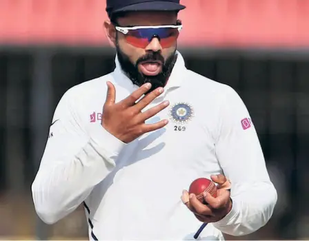  ?? AP ?? Purely on medical grounds: India’s captain Virat Kohli usues saliva to shine the ball during a Test match. “We are trying to create an environ in reducing the risk. We were told by the medical team (of ICC) that saliva was an easy way of carrying the virus,” says Kumble on why the Internatio­nal Cricket Council had taken the decision to ban use of saliva during the pandemic.