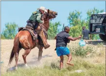  ?? Tribune News Service ?? A U.S. Border Patrol agent on horseback uses the reins to try and stop a Haitian migrant from entering an encampment on the banks of the Rio Grande in Texas last month.