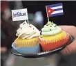  ?? JOE RAEDLE, GETTY IMAGES ?? Cupcakes are decorated with a JetBlue flag and a Cuban flag in Fort Lauderdale, where the flight took off.