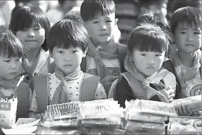  ?? LIU QINLI / FOR CHINA DAILY ?? Children from poor families in Bozhou, Anhui province, receive stationery donated by volunteers. China will work hard to lift about 70 million people in rural areas out of poverty by the end of 2020.