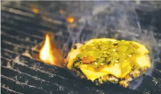  ??  ?? ABOVE: A beef patty topped with green chile and cheese cooks on the grill at Second Steet Brewery as Villarrubi­a makes his El Patron burger.