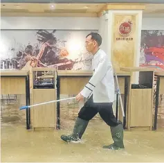  ?? — AFP photo ?? An employee walks through a flooded shopping mall in Heng Fa Chuen district during Super Typhoon Mangkhut in Hong Kong.