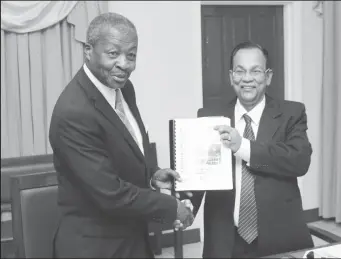  ?? (Photo by Keno George) ?? Auditor General Deodat Sharma (right) presents Speaker of the National Assembly Dr Barton Scotland with the 2015 Auditor’s General’s Report.