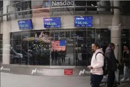  ?? FRANK FRANKLIN II — THE ASSOCIATED PRESS ?? Pedestrian­s walk past the Nasdaq building Tuesday in New York. Trump Media, which runs the social media platform Truth Social, takes Digital World's place on the Nasdaq stock exchange.