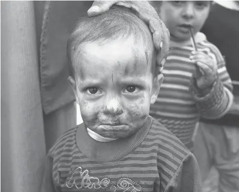  ?? SPENCER PLATT/Getty Images ?? A Syrian child stands in a makeshift refugee camp in Majdal Anjar, Lebanon in 2013. The Conservati­ve government is facing questions about an alleged
anti-Muslim bias in selecting which refugees to allow into Canada.