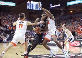  ?? AP Photo/ Zack Wajsgras ?? ■ Duke forward RJ Barrett (5) splits two Virginia defenders during the first half of an NCAA college basketball game Saturday in Charlottes­ville, Va. Duke won, 81-71.