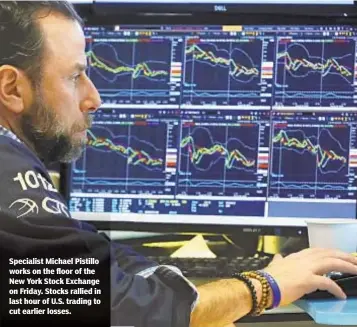  ?? RICHARD DREW/AP ?? Specialist Michael Pistillo works on the floor of the New York Stock Exchange on Friday. Stocks rallied in last hour of U.S. trading to cut earlier losses.