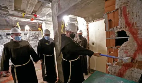  ?? MATT sTONE pHOTOs / HErALd sTAFF ?? GOOD WORK: The Rev. Frank Sevola swings a sledgehamm­er and holds a jackhammer, below, to mark the start of a $1.3 million makeover of the women’s medical clinic at St. Anthony Shrine on Arch Street. He’s joined by fellow friars Tom Conway, Tony LoGalbo and Paul Bourque.