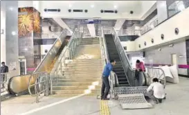  ?? AJAY AGGARWAL/HT PHOTO ?? Workers fixing an escalator at the Kalkaji Mandir Metro station.