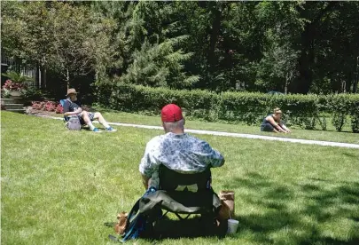  ??  ?? Columnist Mark Brown and others enjoy the parkland outside businessma­n Michael Tadin Jr.’s home on Wednesday.