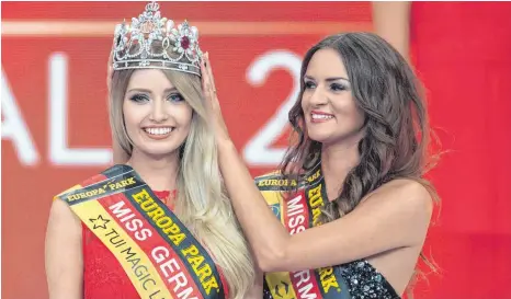  ?? FOTO: DPA ?? „Miss Germany 2017“, Soraya Kohlmann, bekommt von ihrer Vorgängeri­n Lena Bröder die Krone aufgesetzt. Während sich die neue „Miss Germany“Gedanken machen muss, wie es bei ihr mit der Schule weitergeht, kehrt Bröder in ihren Beruf als Lehrerin zurück.