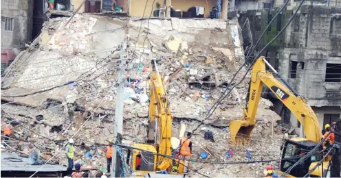  ?? PHOTOS: BENEDICT UWALAKA ?? Rescue workers at the scene of a collapsed three-storey building at No. 87, Odunfa Street, Lagos Island in Lagos yesterday.