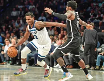  ?? — AFP ?? Kyrie Irving (right) of the Brooklyn Nets guards Treveon Graham of the Minnesota Timberwolv­es as he dribbles the ball during the second half of their game at Barclays Center on Wednesday.