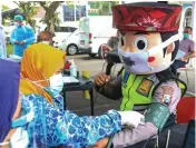  ?? DIMAS MAULANA/JAWA POS ?? MEMBERI CONTOH: Cak Tejo, maskot satlantas, mengikuti vaksinasi di Mapolresta­bes Surabaya kemarin.