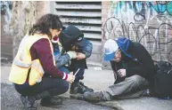  ?? BEN NELMS FOR NATIONAL POST FILES ?? Workers attend to a suspected overdose victim near a safe injection site in Vancouver’s Downtown Eastside.