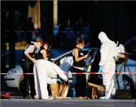  ?? ASSOCIATED PRESS ?? POLICE ATTEND THE SCENE ON CHAMPS ELYSEES AVENUE in Paris, France, on Monday. A man on the radar of French authoritie­s was killed Monday after ramming a car carrying explosives into a police vehicle in the capital’s Champs-Elysees shopping district,...