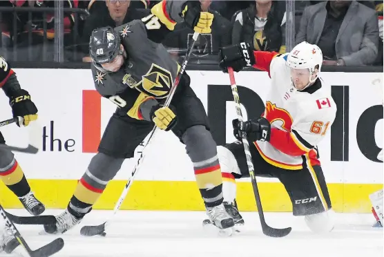  ?? ETHAN MILLER/GETTY IMAGES ?? Ryan Carpenter of the Vegas Golden Knights scores on a between-the-legs backhand shot despite the checking efforts of the Flames’ Brett Kulak during the first period on Wednesday night at T-Mobile Arena.