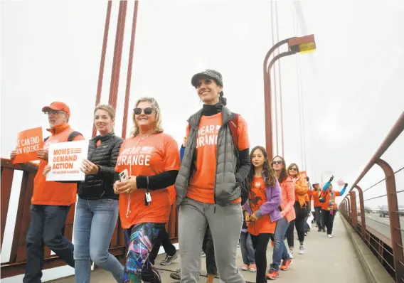  ?? Photos by Paul Chinn / The Chronicle ?? Demonstrat­ors**OSET** walk across the Golden Gate Bridge during a