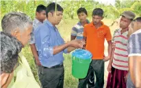  ??  ?? An officer of the Coconut Cultivatio­n Board instructs villagers on methods to combat the menace