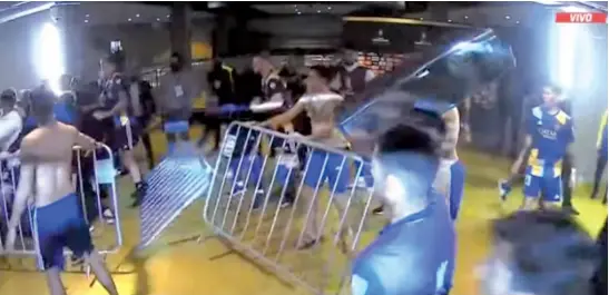  ?? Imagen de tv ?? los jugadores de Boca arremeten contra el vestuario de Mineiro; luego llegaron los gases lanzados por la policía