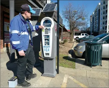  ?? NWA Democrat-Gazette/ANDY SHUPE ?? Luke Bouxsein, a parking enforcemen­t officer with Fayettevil­le, changes a battery Friday on a parking pay station off West Avenue in Fayettevil­le. Consulting firm Nelson/Nygaard has completed a nearly 2-year study of parking downtown. On Tuesday, the...