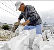  ?? ROGELIO V. SOLIS / ASSOCIATED PRESS ?? Eddy Warner loads sandbags Saturday while preparing for Subtropica­l Storm Alberto in Gulfport, Miss. Warner said he will use the bags as a barrier to keep water from flooding his garage.