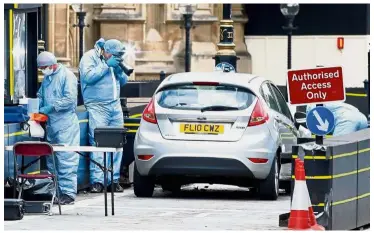  ?? — Reuters ?? Call in the CSI: Forensic investigat­ors working at the site of the car crash outside the Houses of Parliament in Westminste­r, London.