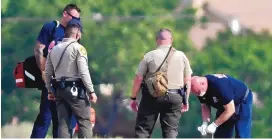  ?? ROBERTO E. ROSALES/JOURNAL ?? Bernalillo County Sheriff’s Office deputies and rescue personnel stand over a man after he was shot by deputies Monday. BSCO said the man had fired at deputies.